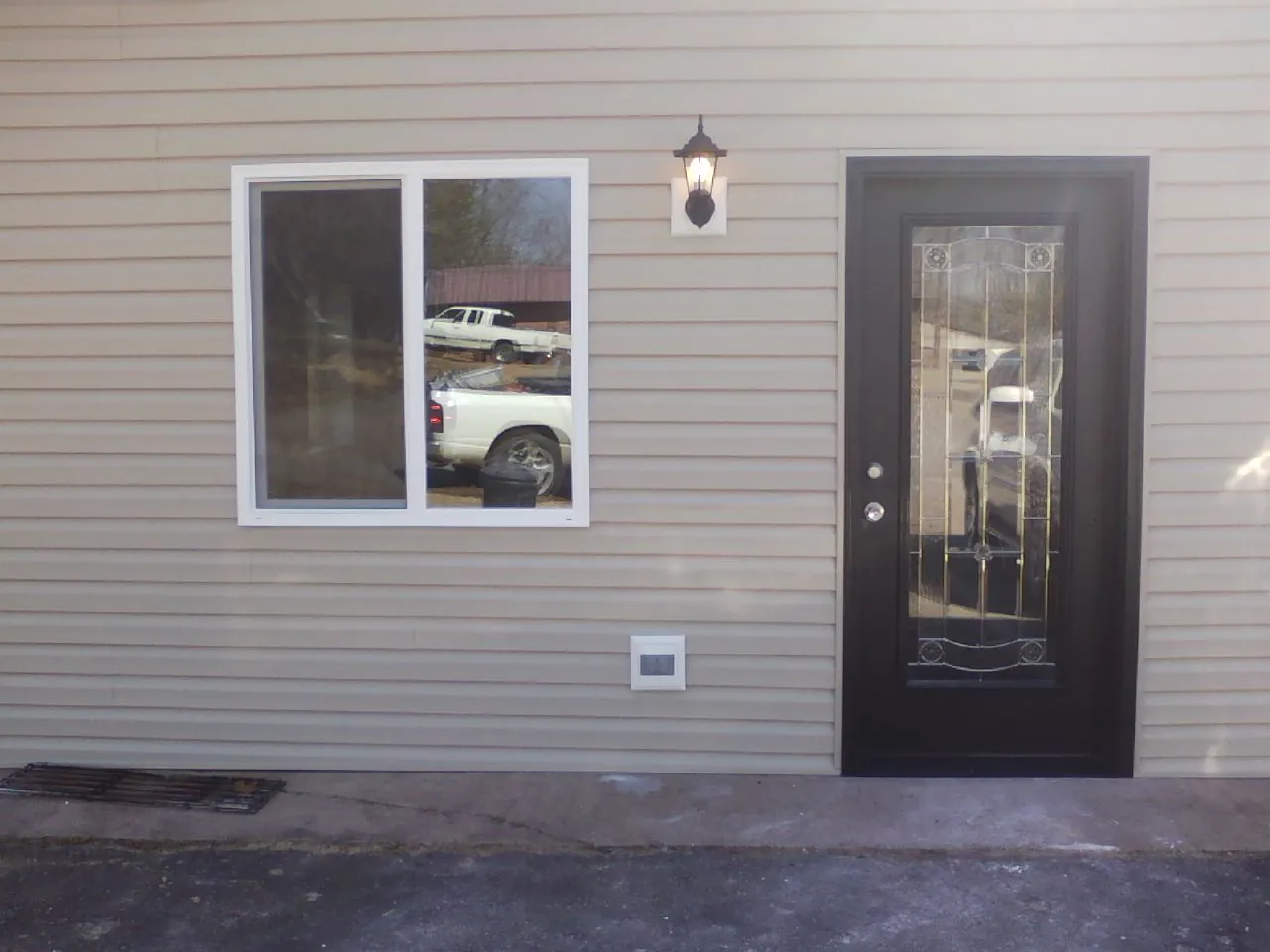 New siding, window and entry door on the side of an addition in Banco