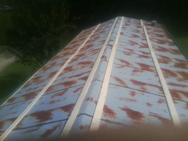 Rusted metal roof panels with new wood purlins before replacement — Storm Damage Roof Repair in Banco by Roofing Brothers
